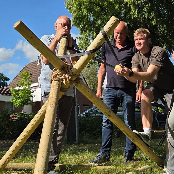 Team bouwt een grote vrijstaande katapult en schiet tennisballen op afstand
