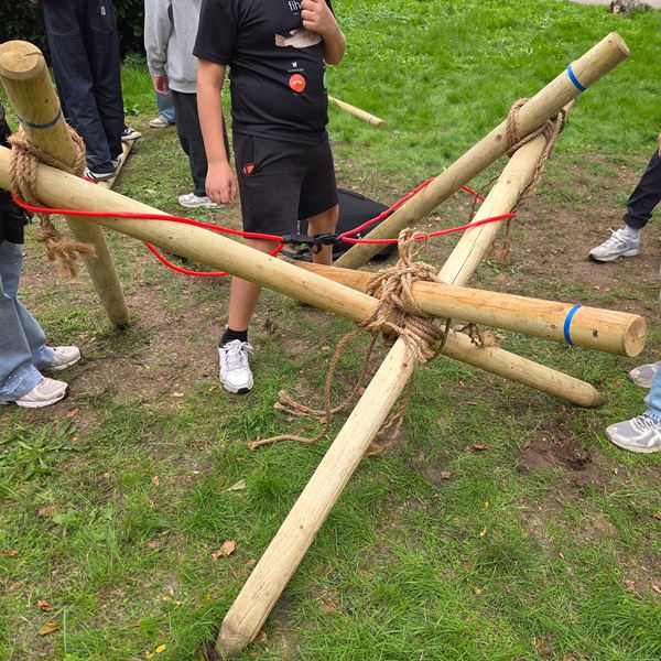 Team bouwt een grote vrijstaande katapult en schiet tennisballen op afstand